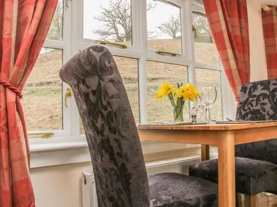 a dining room table with two chairs and a window at Ragleth Place Lodge in Church Stretton