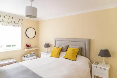a bedroom with a large white bed with yellow pillows at Pelham Grove in Shrewsbury