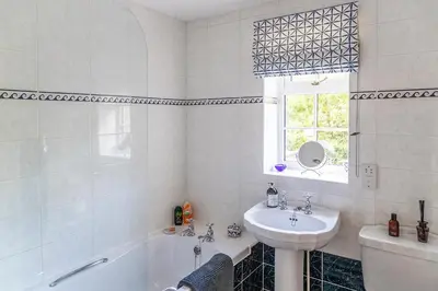 a white bathroom with a sink and a tub and a sink at Pelham Grove in Shrewsbury