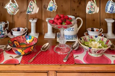 a table with a bowl of strawberries and bowls of spoons at Pelham Grove in Shrewsbury