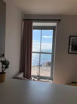 a room with a large window with a view of the ocean at Luxury Sea View Apartment - One Bedroom in Aberystwyth