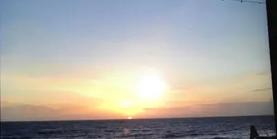 a sunset over the ocean with the sun in the sky at Luxury Sea View Apartment - One Bedroom in Aberystwyth