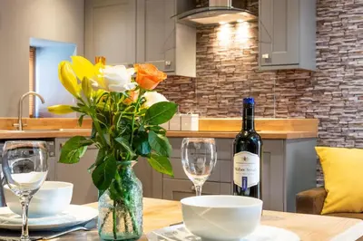a table with a bottle of wine and two glasses at 4 Bed in Bala oc-bow66 in Bala