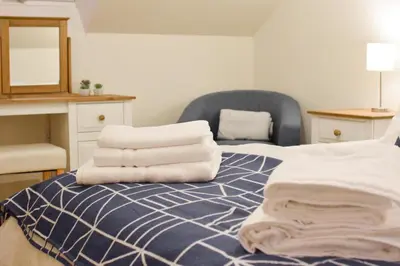 a pile of towels sitting on top of a bed at 3 Bed in Machynlleth oc-bow91 in Penegoes