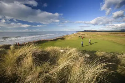 two people playing golf on a golf course next to the ocean at 3 Bed in Machynlleth oc-bow91 in Penegoes