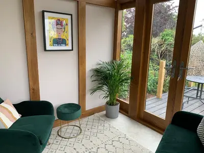 a living room with two green couches and a plant at The Folly in Ludlow