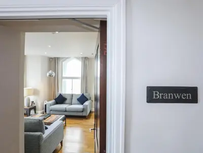 a living room with a couch and a chair at Harlech Apartments - Branwen in Harlech