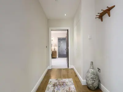 a hallway with white walls and a vase on the floor at Harlech Apartments - Branwen in Harlech