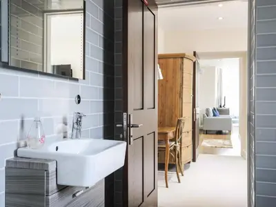a bathroom with a white sink and a mirror at Harlech Apartments - Branwen in Harlech