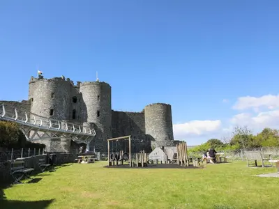 a castle with a playground in front of it at Harlech Apartments - Branwen in Harlech