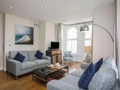 a living room with two couches and a table at Harlech Apartments - Branwen in Harlech