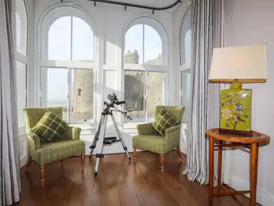 a room with a camera and two chairs and a lamp at Harlech Apartments - Bendigeidfran in Harlech