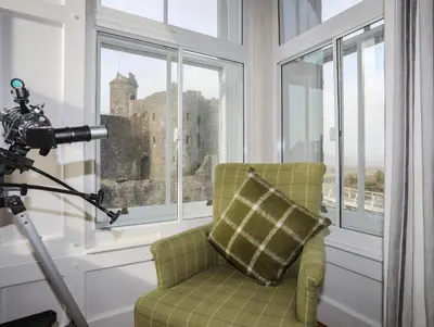 a camera operator taking a picture of a chair in a room with windows at Harlech Apartments - Bendigeidfran in Harlech