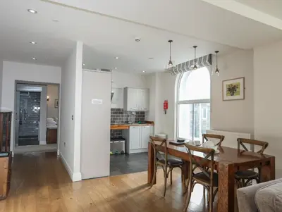 a kitchen and dining room with a table and chairs at Harlech Apartments - Bendigeidfran in Harlech