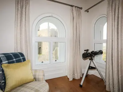 a camera on a tripod in a room with a window at Harlech Apartments - Gwern in Harlech