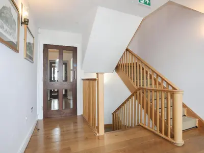 a staircase in a home with a wooden stair case at Harlech Apartments - Gwern in Harlech