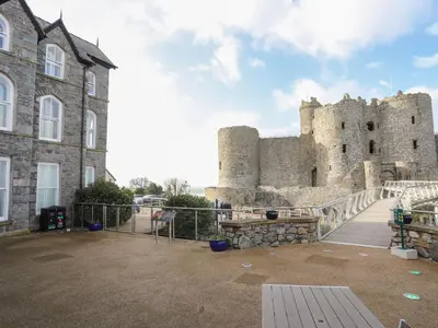 a castle with a fence in front of it at Harlech Apartments - Gwern in Harlech