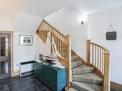 a room with a staircase with a boat on a dresser at Harlech Apartments - Gwern in Harlech