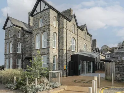 an old stone building with a courtyard in front of it at Harlech Apartments - Matholwch in Harlech