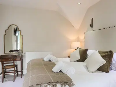 a bedroom with a bed with a mirror and a table at Harlech Apartments - Matholwch in Harlech