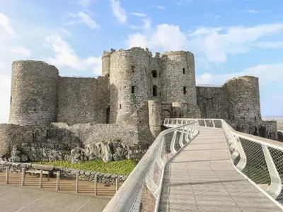 a castle with a bridge in front of it at Harlech Apartments - Matholwch in Harlech