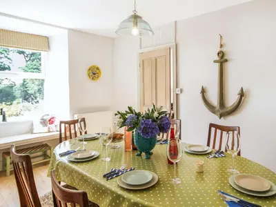 a dining room table with a green polka dot table cloth at Big House in Llandecwyn