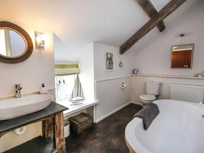 a bathroom with a white tub and a sink at Big House in Llandecwyn