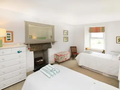 a bedroom with two beds and a fireplace at Big House in Llandecwyn