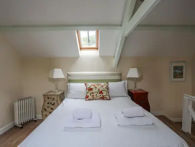 a bedroom with a large white bed with two pillows at Little House in Llandecwyn