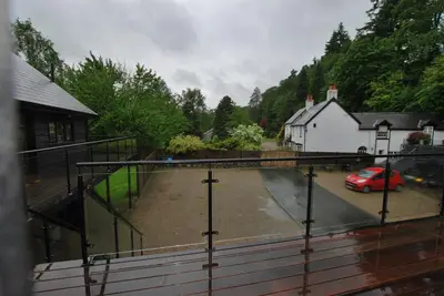 a view of a parking lot with a red car at The Coach House Annexe in Llangollen