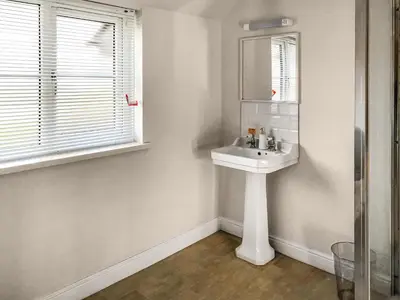 a white bathroom with a sink and a mirror at Brynich Villa in Brecon