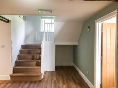 a staircase in a home with green walls and wooden floors at Brynich Villa in Brecon