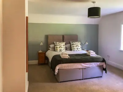 a bedroom with a bed and a green wall at Brynich Villa in Brecon