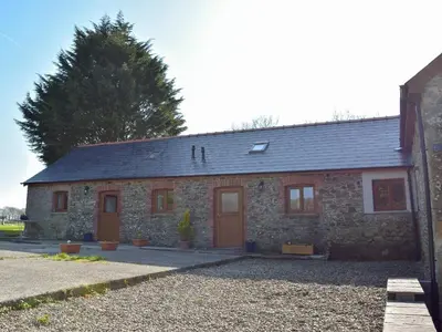 a stone building with two doors on the side of it at Hen Llaeth - Uk11209 in Cwrt-newydd