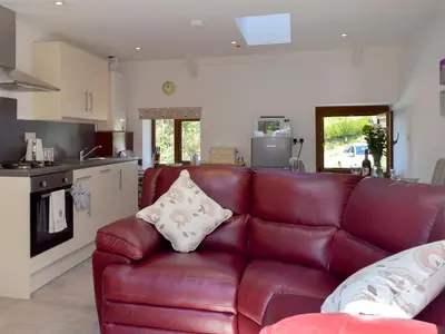 a living room with a red leather couch at Hen Llaeth - Uk11209 in Cwrt-newydd