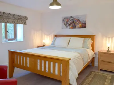 a bedroom with a bed with a wooden bed frame at Hen Llaeth - Uk11209 in Cwrt-newydd