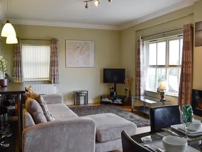 a living room with a couch and a tv at Powis Castle View in Forden