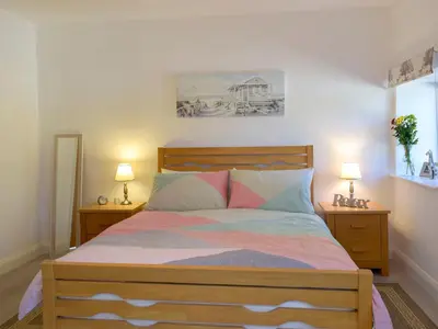 a bedroom with a wooden bed with two night stands at Parlwr - Uk11210 in Cwrt-newydd