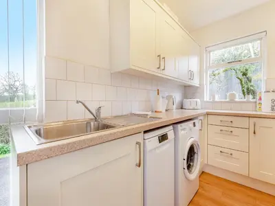 a white kitchen with a sink and a dishwasher at Cambrian Mountain View in Llanafan-fawr