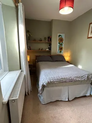 a bedroom with a white bed and a window at Cynfaen house in Corwen
