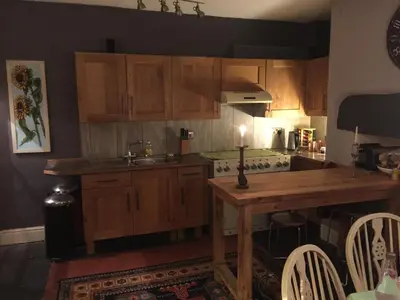 a kitchen with wooden cabinets and a wooden table at Cynfaen house in Corwen