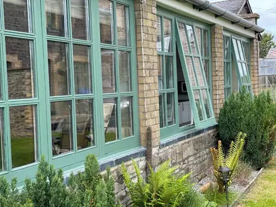 a conservatory with green windows on a house at Tegfan Garden Suite in Talgarth