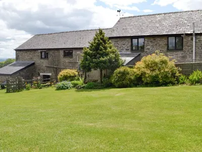 a stone house with a tree in a yard at Woodland View-Uk11826 in Llandefaelogfâch