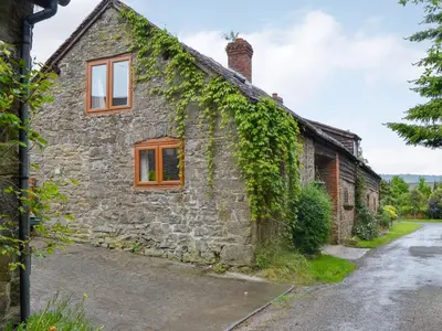 an old stone house with ivy growing on it at Lower Barn in Wistanstow