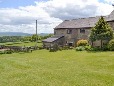 an old stone barn with a picnic table in a yard at Mountain View-Uk11825 in Llandefaelogfâch