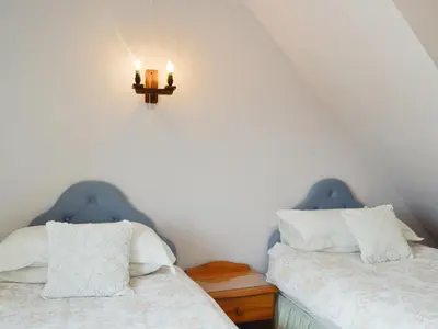 two beds in a room with two candles on the wall at Mountain View-Uk11825 in Llandefaelogfâch