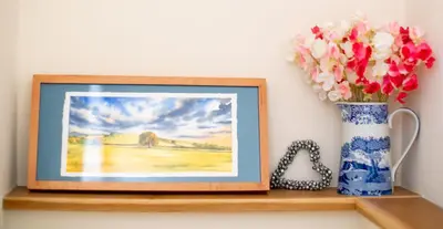 a picture of a vase of flowers on a shelf at Magnolia Cottage in Church Stretton