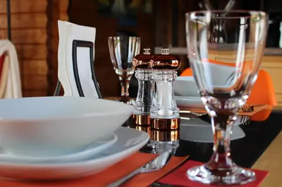 a table with two wine glasses and plates on it at Long Wood Lodges in Knighton