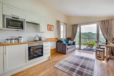 a kitchen with white cabinets and a living room at 1 Bed in Lower Chapel oc-waa906 in Lower Chapel