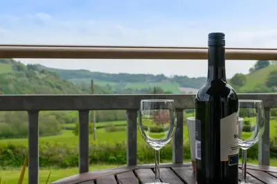 a bottle of wine sitting on a table with two wine glasses at 1 Bed in Lower Chapel oc-waa906 in Lower Chapel